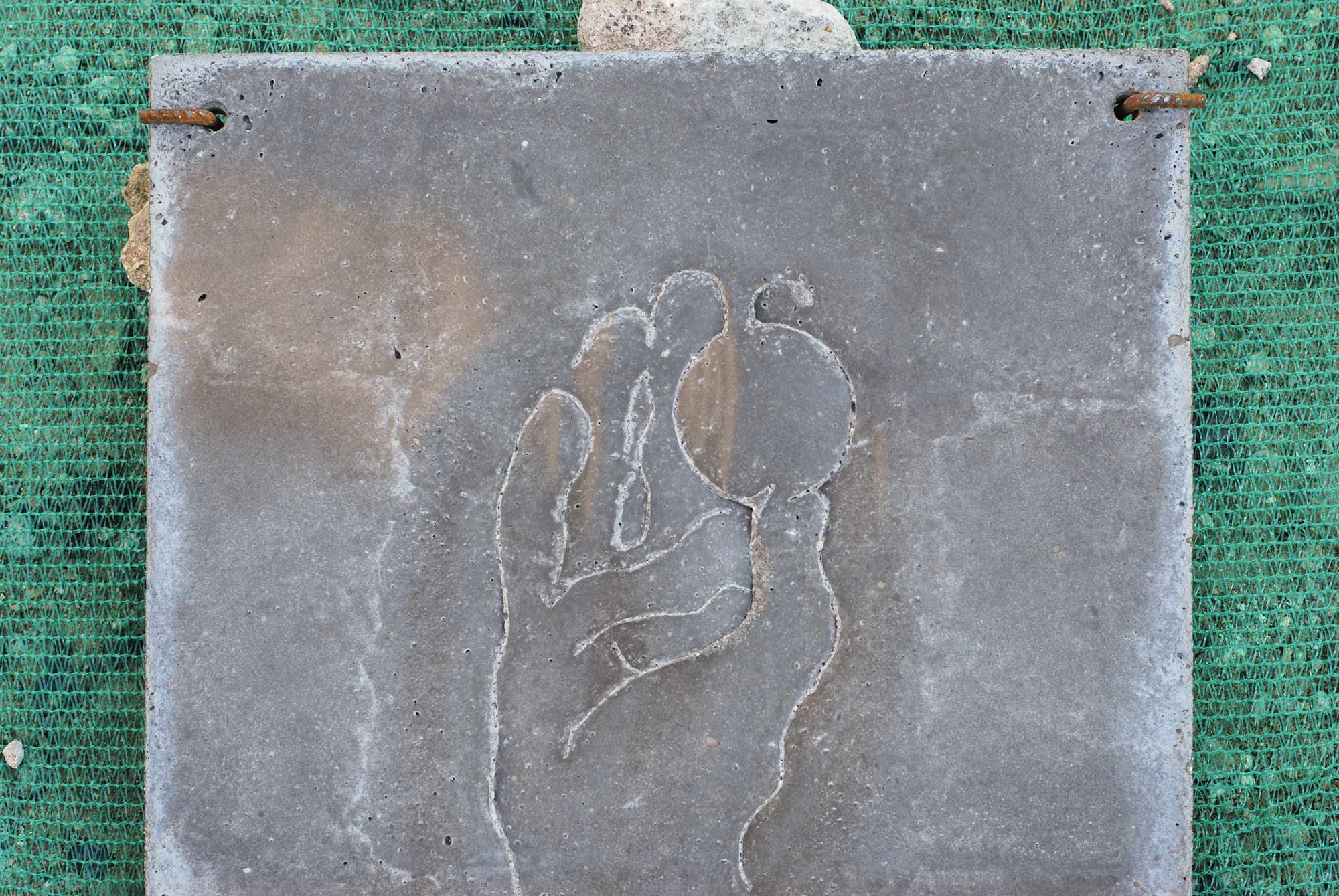 Cher Thésée, Pierre Feller, Sébastien Hoëltzener, détail, la plaque en béton gravé, avec la main qui tient une sphère, symbole de pouvoir, main de l'empereur romain